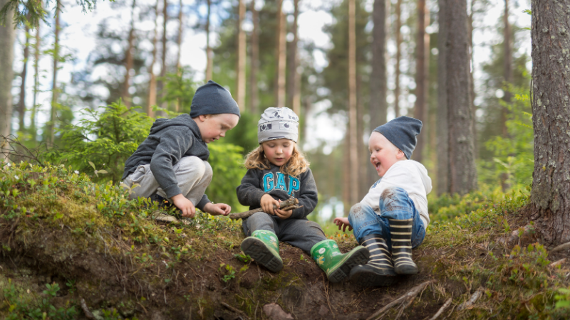 Lapset leikkivät metsässä.