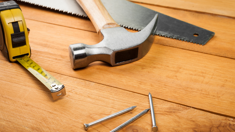 Vasara, saha ja nauloja pöydällä.