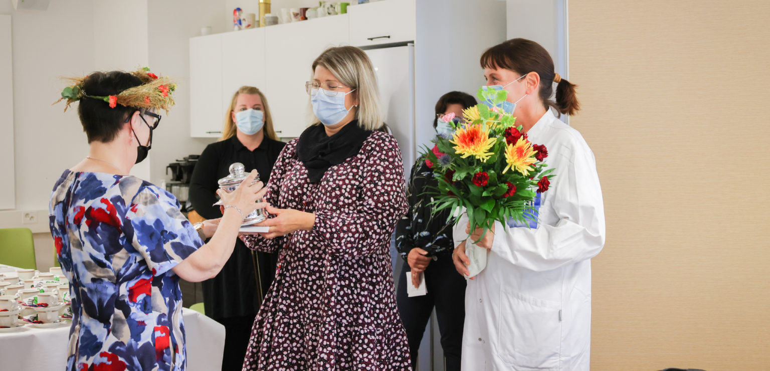 Eläkel'isjuhlissa Maire Takina-ahoa kukittamassa Outi Kokko ja Pauliina Sarajärvi.