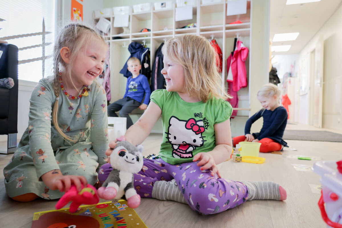 Hymyilevät tytöt leikkivät päiväkodissa