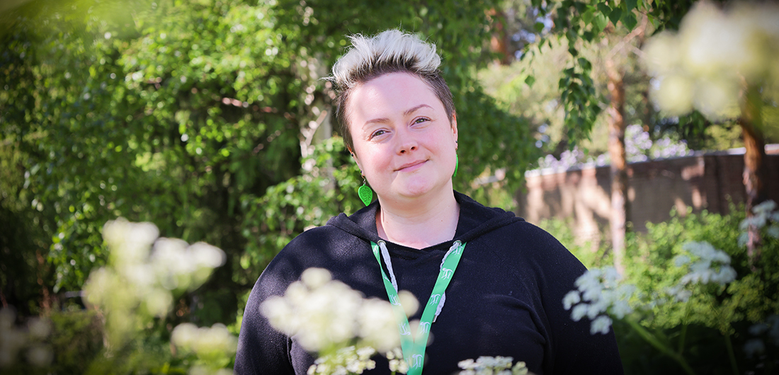 Viestintäharjoittelija Maria Nikkilä hyyilee kesäisessä kuvassa.