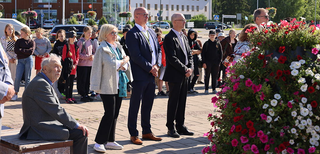 Ihmiset seisovat Limingan torilla kuuntelemassa maakuntajohtajan puhetta.