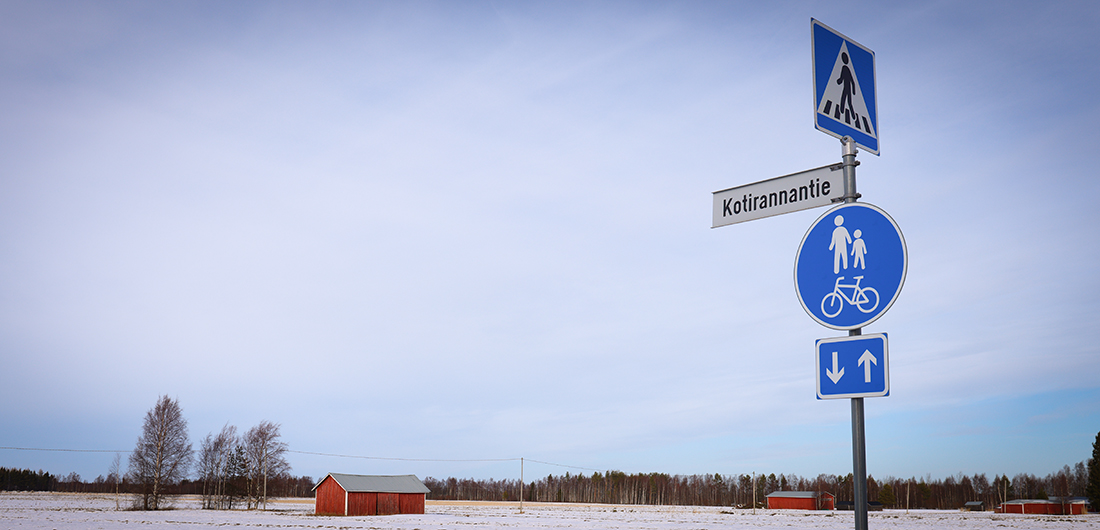 Kotirannan tienviitta ja peltomaisema.
