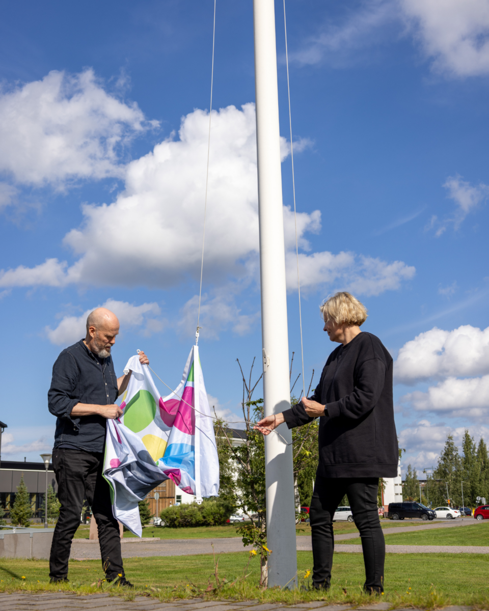 Paula Noronen ja Janne Nevala nostavat Limmi-lippua salkoon.