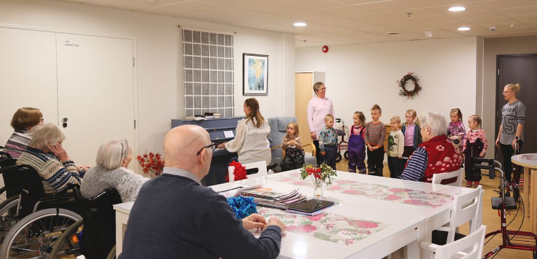 Vanhukset kuuntelevat lasten musiikkiesitystä.