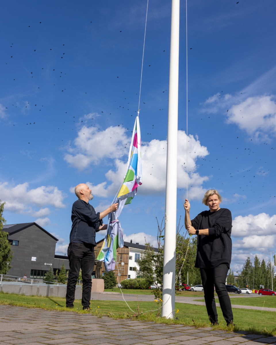 Paula Noronen ja Janne Nevala nostavat Limmi-lippua salkoon.