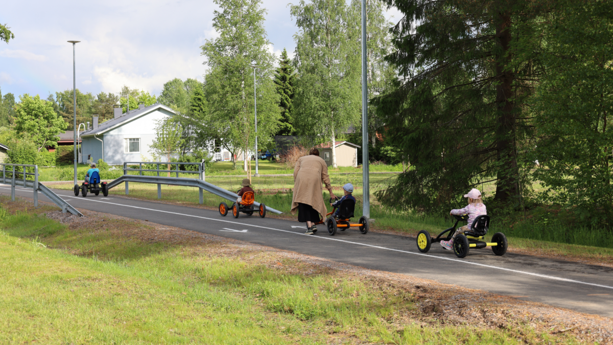 Lapsia ajamassa polkuautoilla.