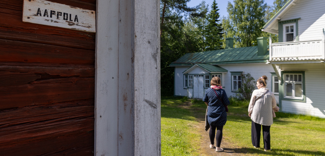 Kaksi henkilöä kävelee valkoisen talon edustalla Vanhassa Limingassa.