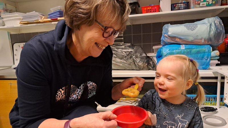 Kuvassa Alisa Koskela tarjoilee isovanhemmalleen Marja Koskelalle leikkikakkua.