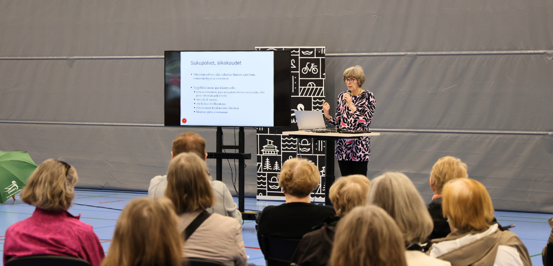 Valokuvassa geriatri Marja-Liisa Karjula ja luennon kuuntelijoita.