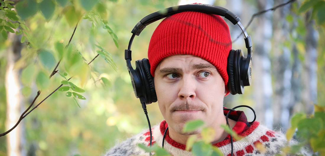 Luontodokumentaristi Sakke Kustoon roolia näyttelevä Aku Sipola kuulokkeet päässä.