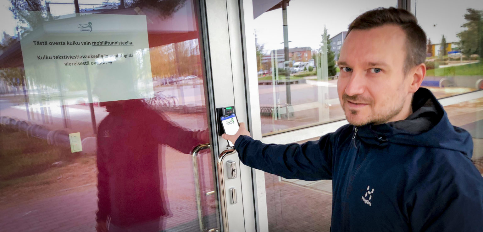 Liikuntapalvelupäällikkö Janne Laamanen avaa kuntosalin ovea älypuhelimellaan.