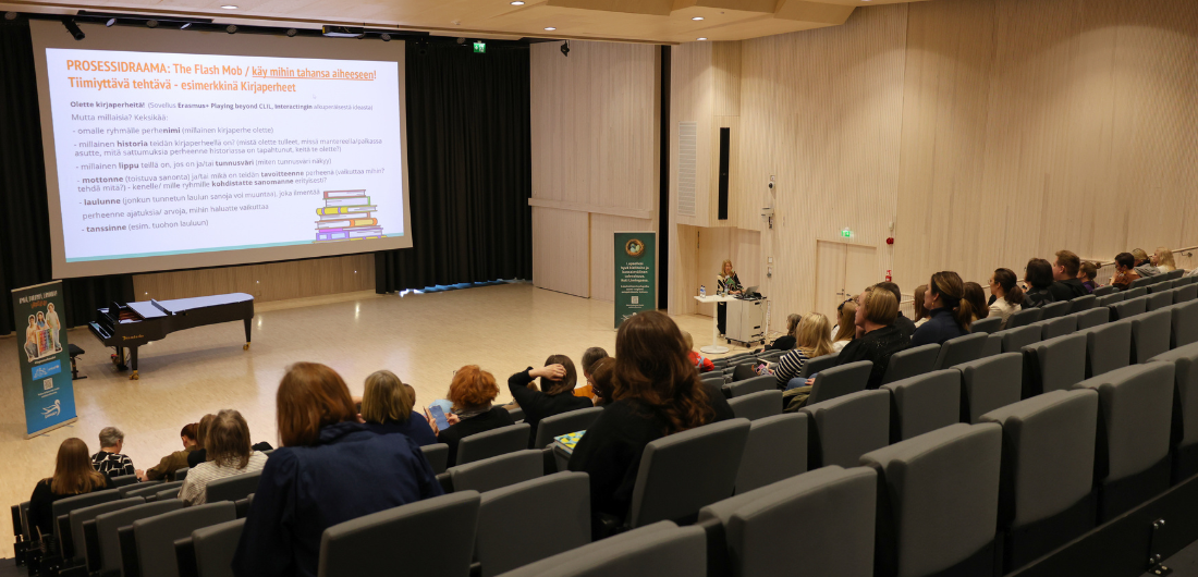 Valokuva Heikki Sarvela -salista, jossa istuu osallistujia kuuntelemassa luentoa.