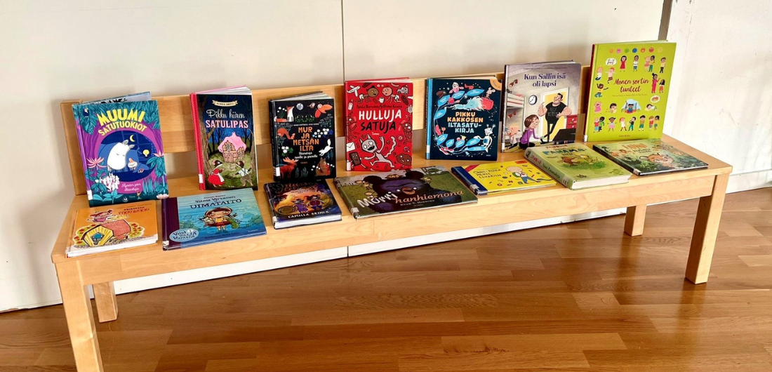 Lasten kirjoja esillä penkin päällä.