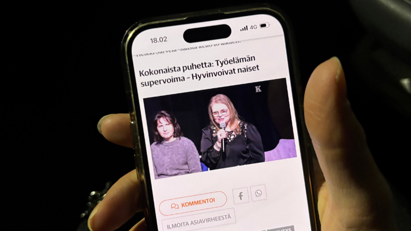 Käsi pitelee puhelinta, jossa on avoinna Kalevan sivu ja Kokonaista puhetta -klubin striimi.