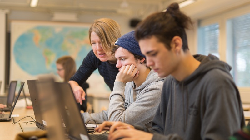 Opettaja ohjaa oppilaita luokassa.