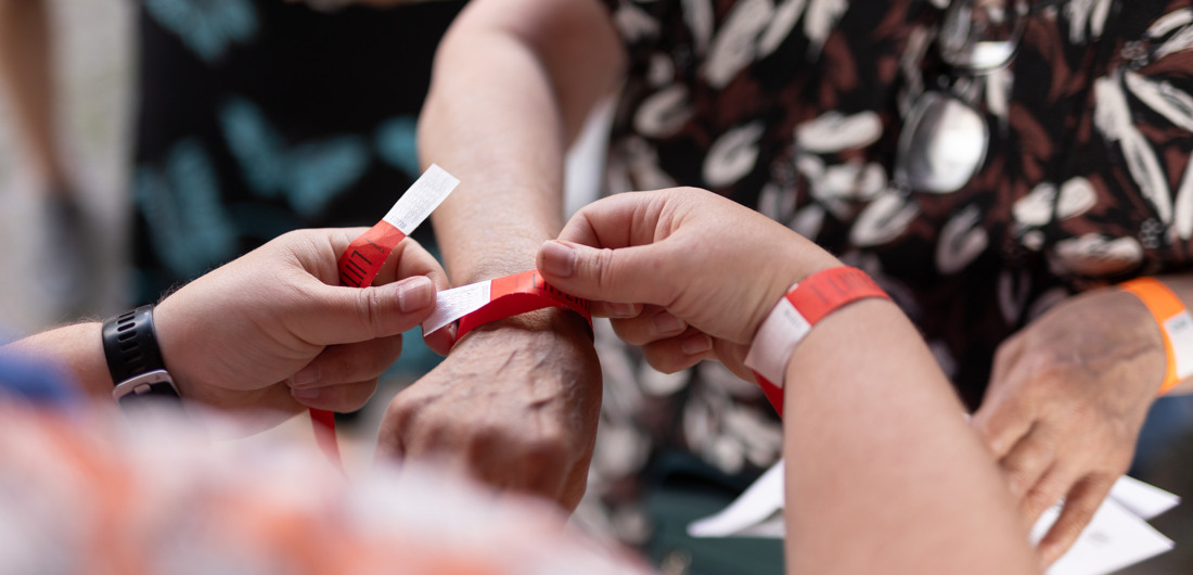 Kädet kiinnittävät tapahtumaranneketta kävijän ranteeseen.