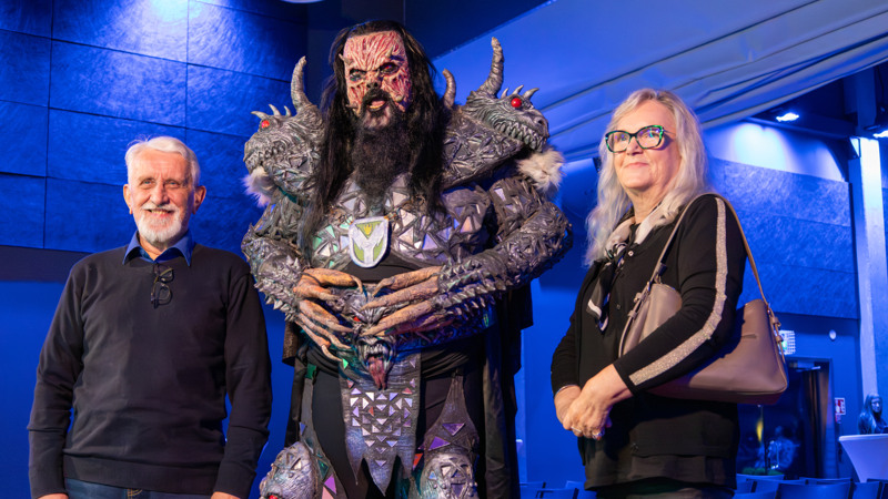 Valokuvassa eläinekologian emeritusprofessori Erkki Korpimäki, mr. Lordi ja taiteilija Marga Tikka.