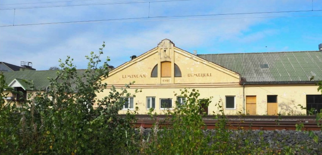 Valokuvassa ratakiskot ja niiden takana häämöttävä Limingan osuusmeijerin rakennus.