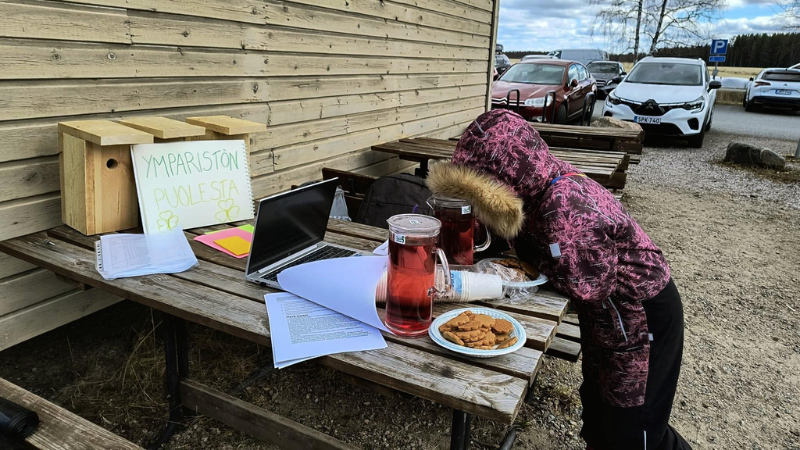 Valokuvassa lapsi talkoopisteellä ulkona.