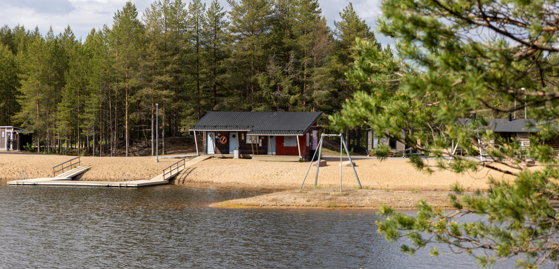 Rantakylän uimaranta ja huoltorakennus kesäisenä päivänä.