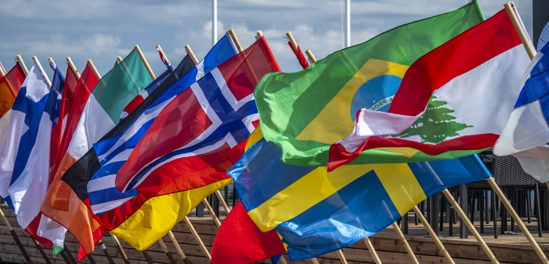 Kuvassa heiluu eri maiden lippuja.