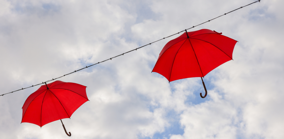 Kaksi punaista sateenvarjoa roikuu ilmassa