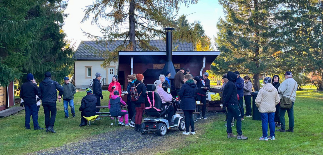 Osallistujia vanhusten viikon toimintarastilla, nuotiokahvipisteellä.