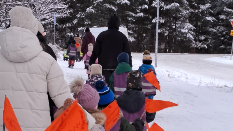 Lapsen oikeuksien marssi Tupoksessa. Kuvassa lapsia ja aikuisia talviasuissa selkäpuolelta kuvattuna.