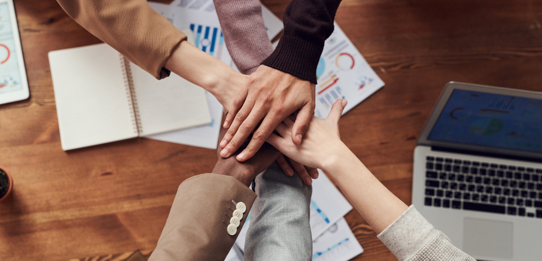 Kädet päällekkäin työpöydän päällä.