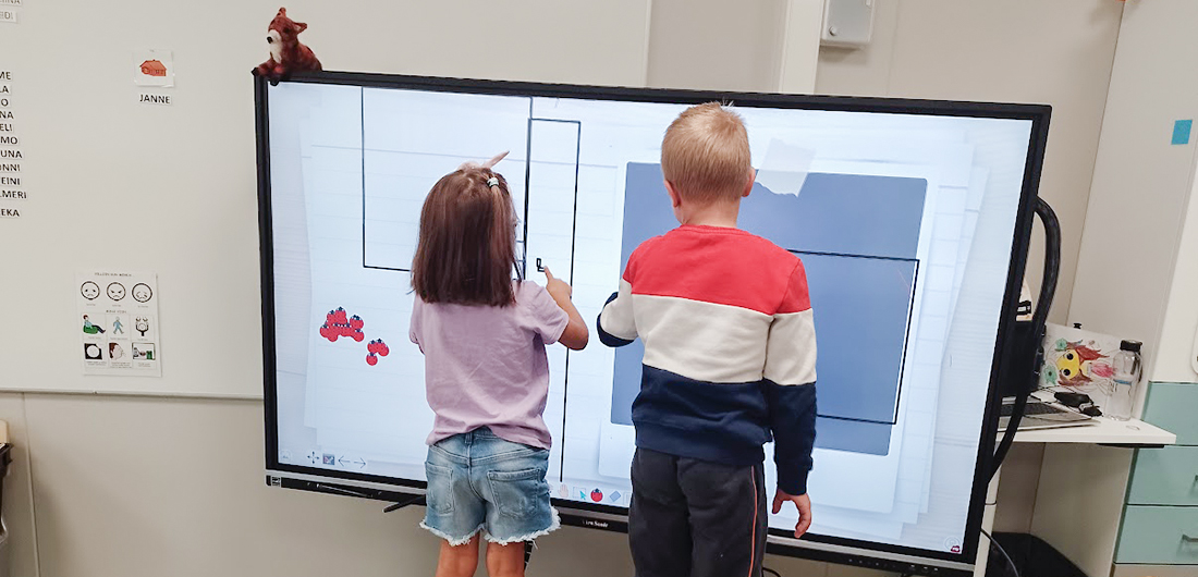 Lapset testaavat älytaulun toimintaa.