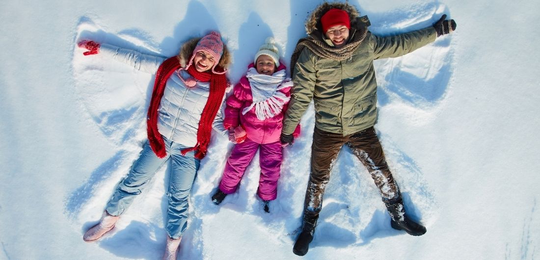 Perhe tekee lumienkeleitä