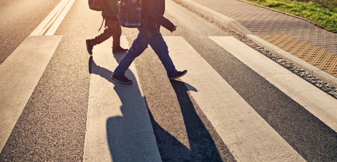 Koululaiset kävelevät suojatiellä.