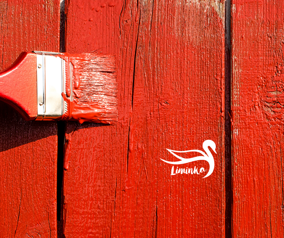 Punainen maalipensseli lautaseinällä.