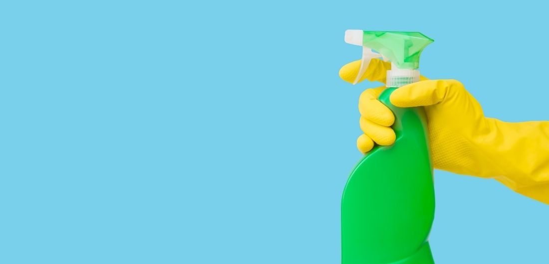 Kädessä pidellään vihreää suihkupulloa..