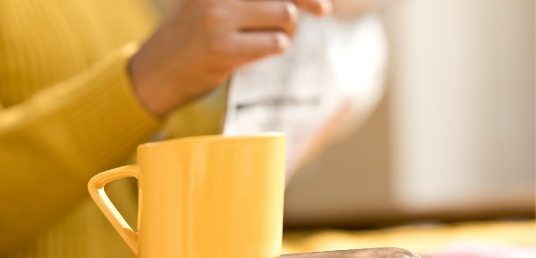 Keltapaitainen henkilö lukee sanomalehteä.