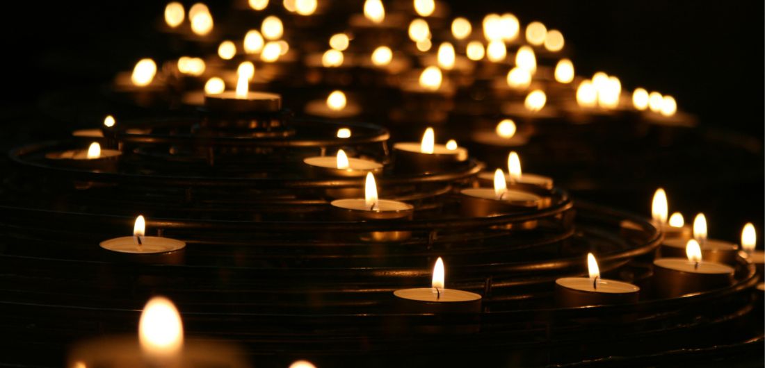 Tuikkukynttilöiden liekit loistavat pimeässä.