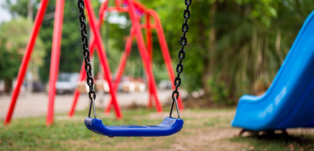 Leikkipuiston keinu ja liukumäki.