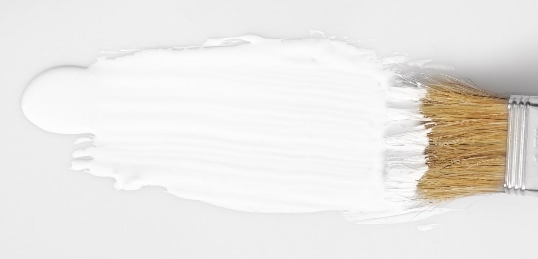 Valkoisella maalilla maalataan pintaa.
