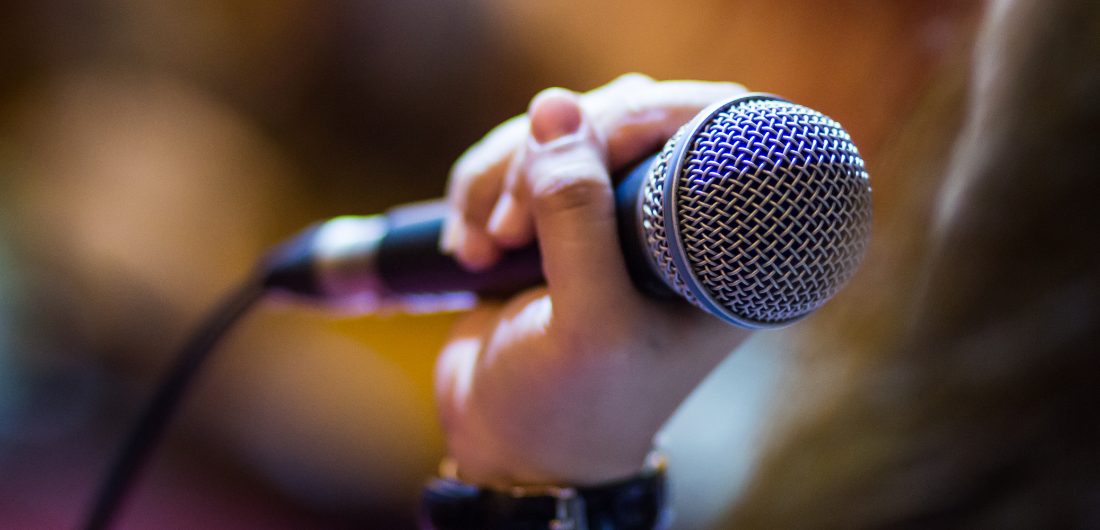 Käsi pitelee mikrofonia.