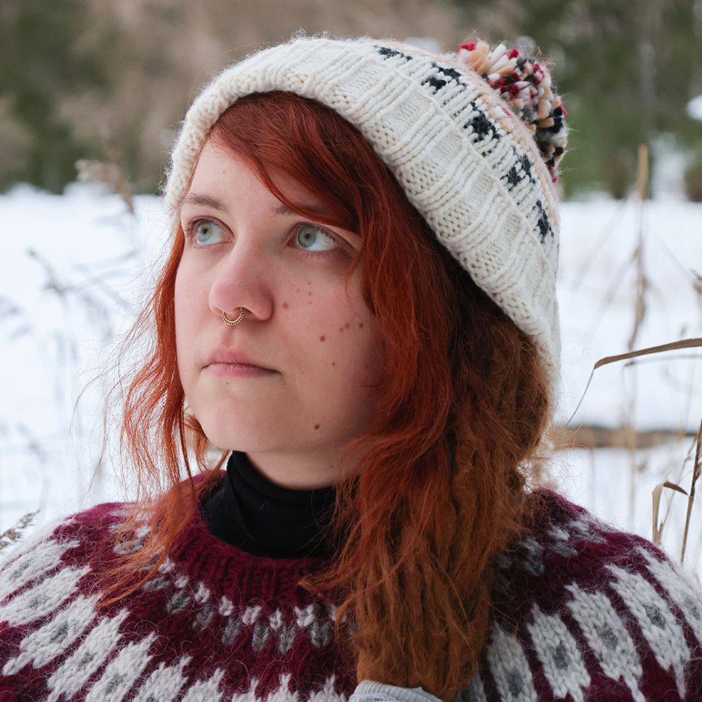 Nainen tuijottaa talvisessa maisemassa.