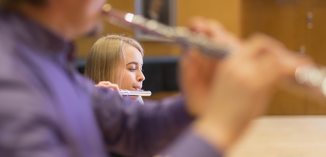 Opiskelija soittaa poikkihuilua opettajansa kanssa.