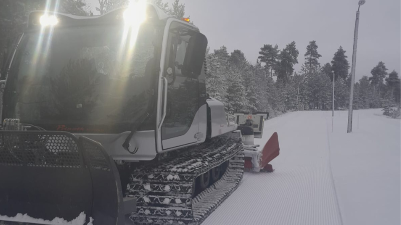 Kuvassa on latukone ja hiihtolatu