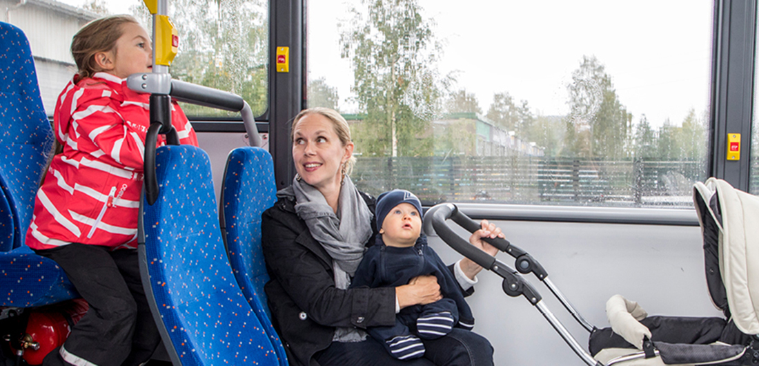 Äiti ja lapset bussin kyydissä.