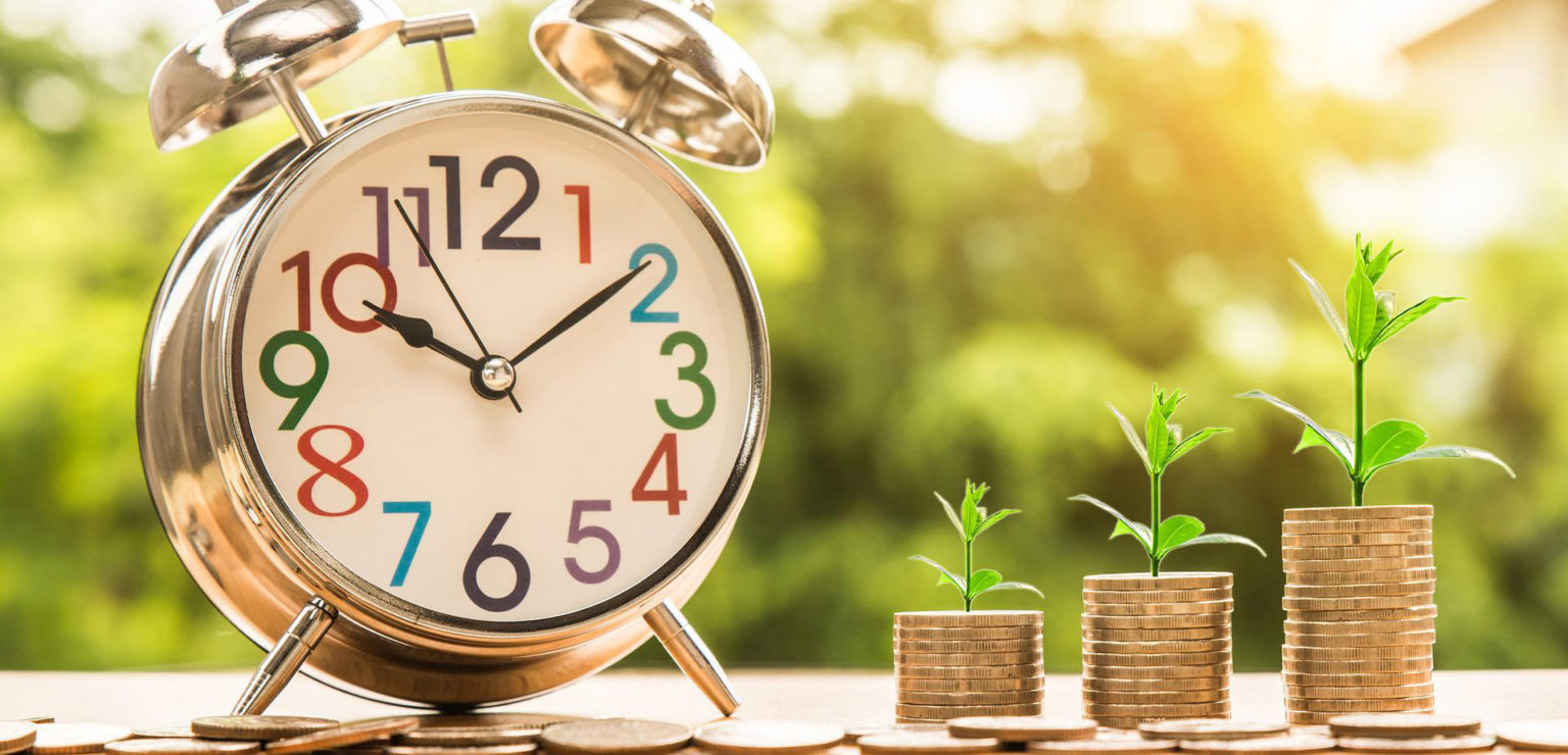 Herätyskello, jonka vieressä itäviä kolikkopinoja.