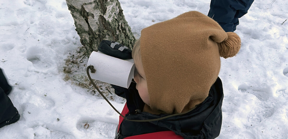 Lapsi kiikaroi pahvikiikarilla.