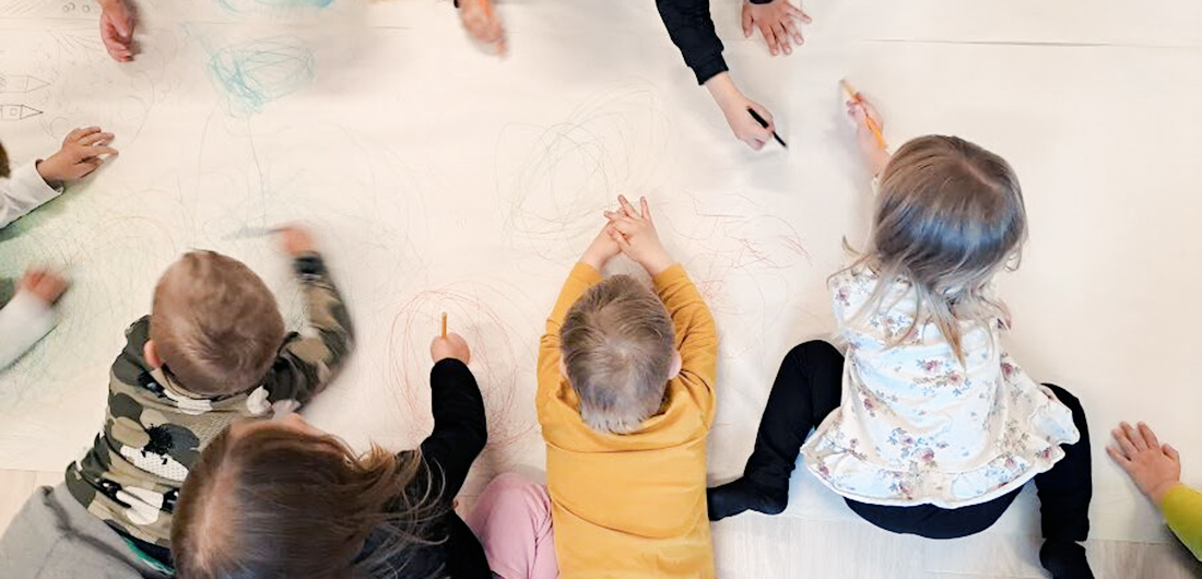 Lapset piirtävät lattialla.