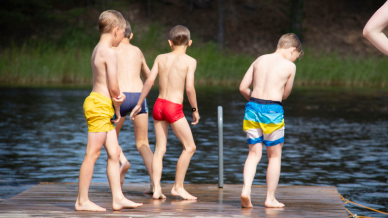 Lapset seisovat uimalaiturilla Rantakylässä.