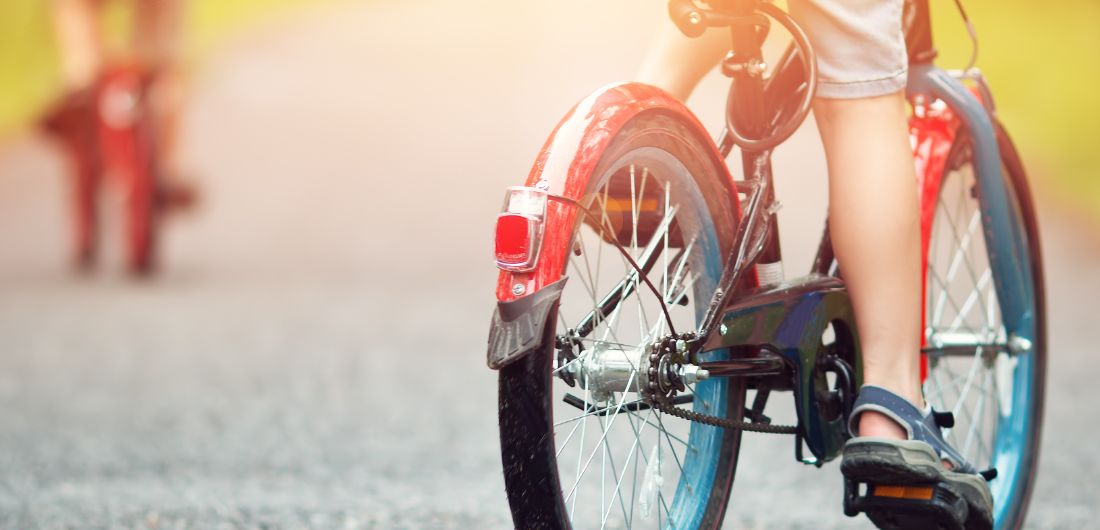 Lapsi pyöräilee tiellä.