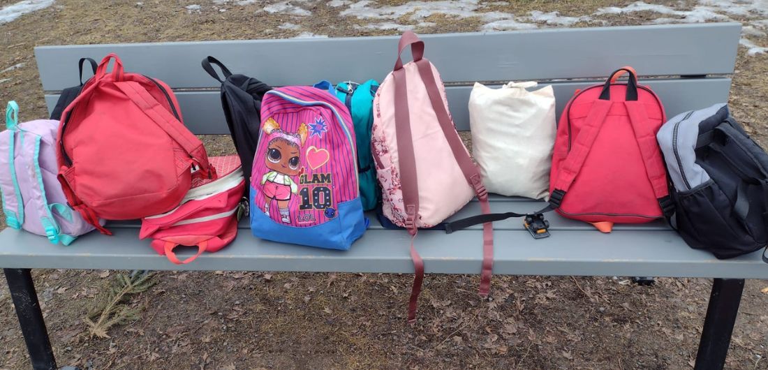 Lasten reppuja puiston penkillä.